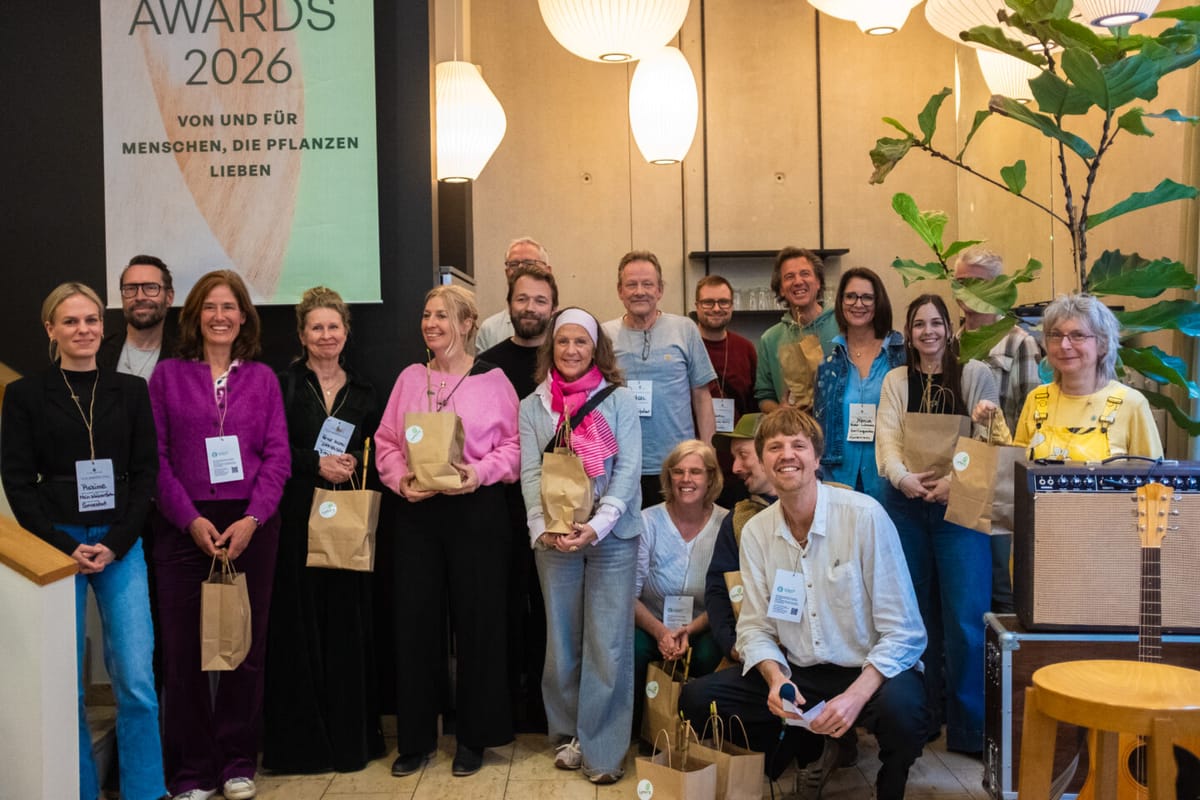 Gruppe von Menschen mit Geschenktüten, die vor einer Wand mit einem Banner für die Tilia Awards 2026 posiert.